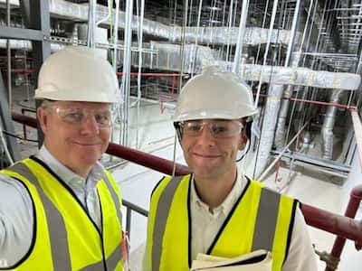 Two Ramskov colleagues in hard hats and hi-vis on a factory visit